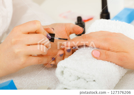 Woman in beauty salon getting manicure done. Woman in beauty salon getting manicure done. 127376206