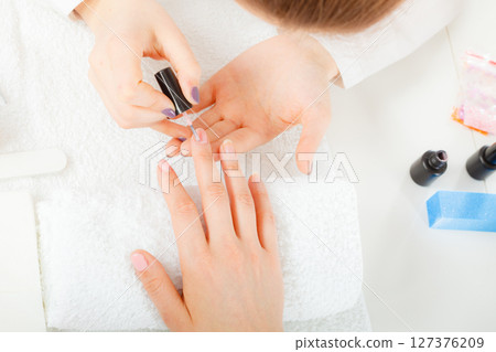 Woman in beauty salon getting manicure done. Woman in beauty salon getting manicure done. 127376209