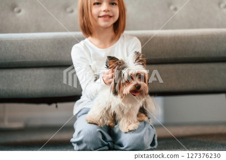 Little girl is at home with cute dog Little girl is at home with cute dog 127376230