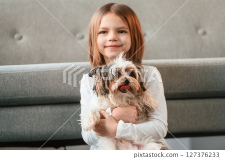 Portrait of little girl that is at home with cute dog Portrait of little girl that is at home with cute dog 127376233