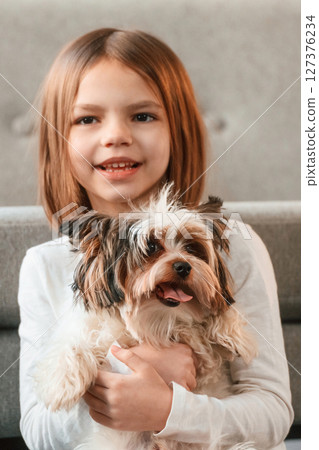 Portrait of little girl that is at home with cute dog 127376234