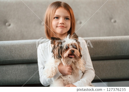 Portrait of little girl that is at home with cute dog Portrait of little girl that is at home with cute dog 127376235