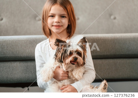 Portrait of little girl that is at home with cute dog Portrait of little girl that is at home with cute dog 127376236