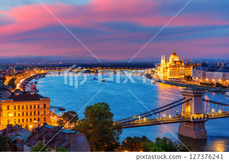 Panoramic evening view of Budapest with Parliament building, Chain Bridge and Danube river at sunset Panoramic evening view of Budapest with Parliament building, Chain Bridge and Danube river at sunset 127376241