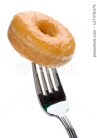 Glazed donut on fork isolated, sweet pastry dessert, sugar icing drip 127376374