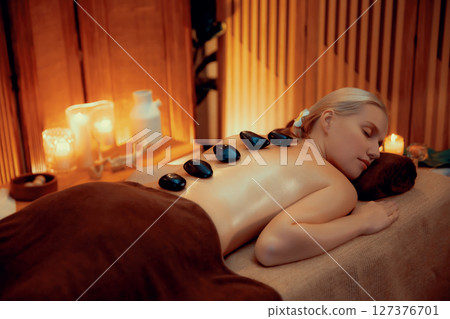 Hot stone massage at spa salon in luxury resort with warm candle light.Quiescent 127376701