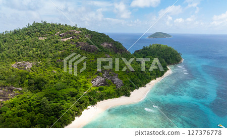 Aerial view of island with a sandy beach and tropical vegetation. Seychelles, Therese island. 127376778