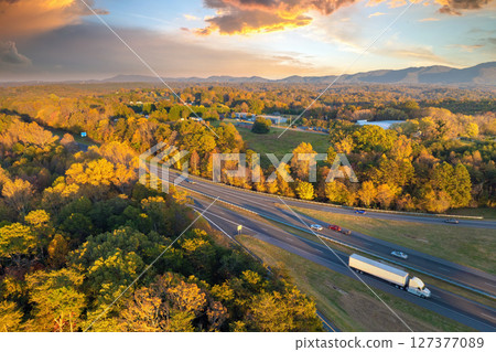 Wide multilane highway road in USA Appalachian mountains with fast driving semi trucks. Above view of American transportation infrastructure 127377089
