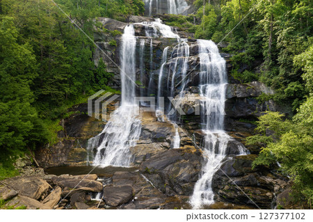 Whitewater Falls with falling down clear water from rocky boulders between green lush woods in Nantahala National Forest, North Carolina, USA Whitewater Falls with falling down clear water from rocky boulders between green lush woods in Nantahala National Forest, North Carolina, USA 127377102