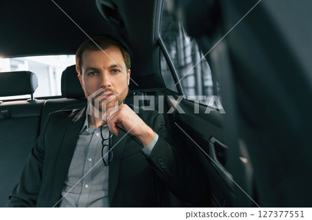 In comfortable modern automobile. Man in formal business clothes In comfortable modern automobile. Man in formal business clothes 127377551