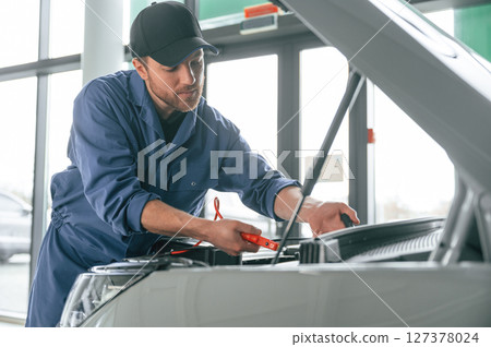 Man in blue uniform is working in the car service 127378024