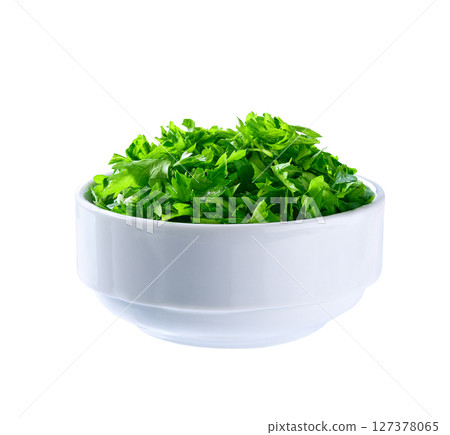 Chopped parsley in a ceramic bowl isolated on white background. Clipping path. 127378065