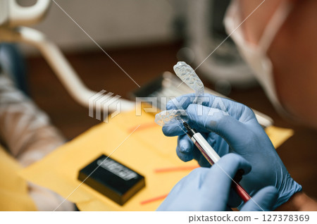 The aligner. Close up view of dentist equipment. Doctor with gloves 127378369