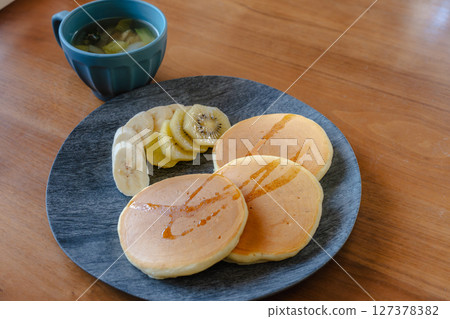 鬆軟的煎餅和水果早餐 | 時尚餐桌的完美形象 鬆軟的煎餅和水果早餐 | 時尚餐桌的完美形象 127378382