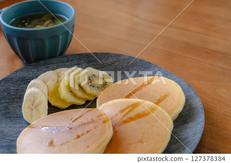 Fluffy pancakes and fruit breakfast | A perfect image for a stylish dining table Fluffy pancakes and fruit breakfast | A perfect image for a stylish dining table 127378384