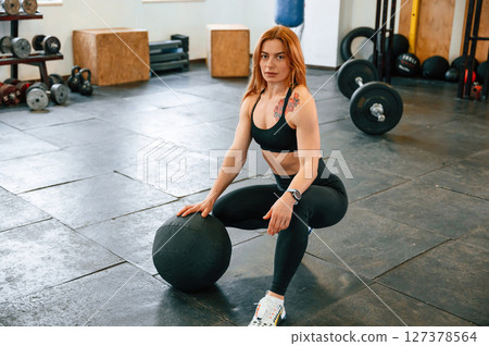 Sitting, relaxed. Beautiful strong woman is in the gym 127378564
