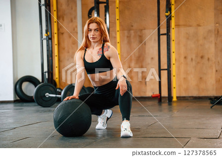 Sitting, relaxed. Beautiful strong woman is in the gym 127378565