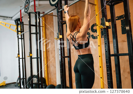 Pull-up exercise. Beautiful strong woman is in the gym Pull-up exercise. Beautiful strong woman is in the gym 127378640