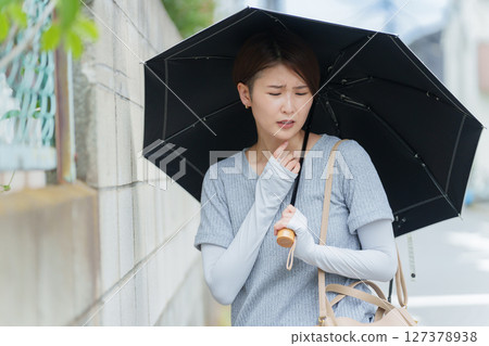 A woman staggering with heat stroke 127378938