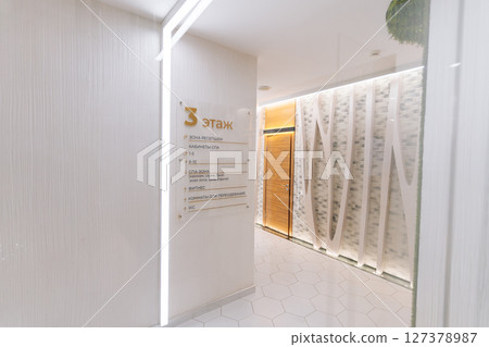 Modern minimalist interior of beauty clinic corridor showing floor plan with directions to different treatment rooms, spa, fitness area and restrooms, no people, nobody. 127378987