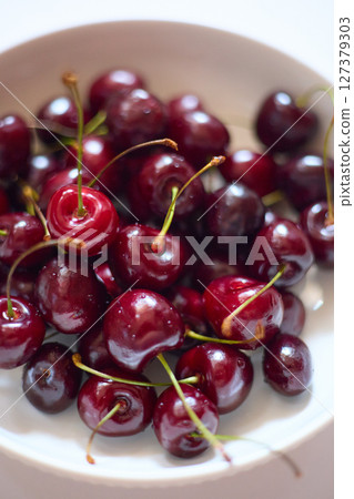 glass plate with ripe cherries close-up 127379303