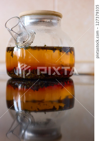 tea is brewed in a glass teapot, evaporation drops on the walls of the teapot 127379335