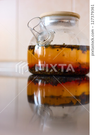 tea is brewed in a glass teapot, evaporation drops on the walls of the teapot tea is brewed in a glass teapot, evaporation drops on the walls of the teapot 127379361
