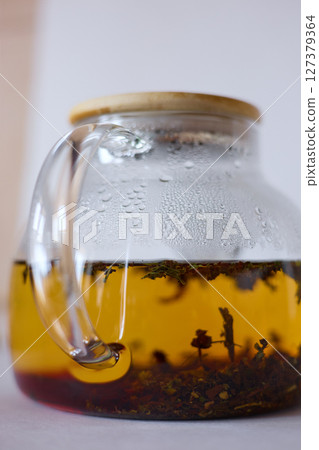 tea is brewed in a glass teapot, evaporation drops on the walls of the teapot tea is brewed in a glass teapot, evaporation drops on the walls of the teapot 127379364