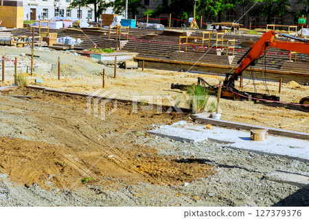 Heavy machinery is actively working on construction site where groundwork is being prepared for future development. Heavy machinery is actively working on construction site where groundwork is being prepared for future development. 127379376