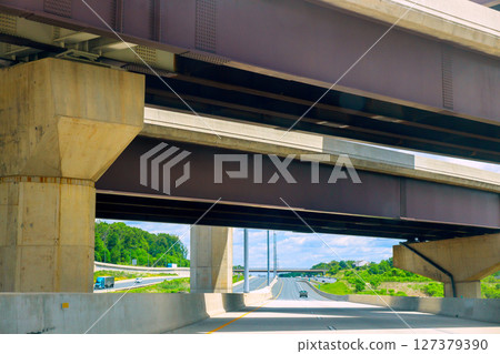 Elevated highway structure spans over dual carriageway under clear blue skies Elevated highway structure spans over dual carriageway under clear blue skies 127379390