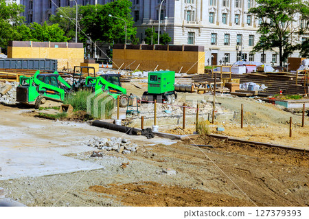 Construction site featuring machinery materials in an urban area during works day Construction site featuring machinery materials in an urban area during works day 127379393