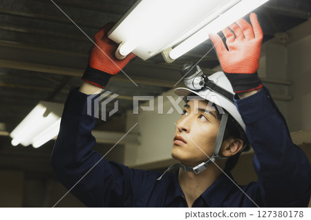 A man in work clothes with his arms folded A man in work clothes with his arms folded 127380178