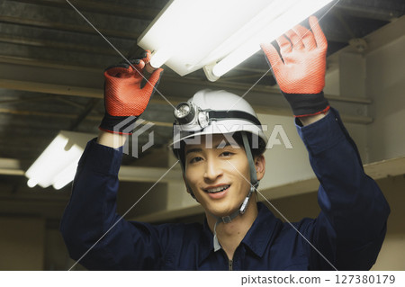 A man in work clothes with his arms folded 127380179