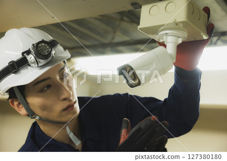 一名身穿工作服、雙臂交叉的男子 127380180