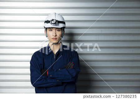 A man in work clothes with his arms folded 127380235