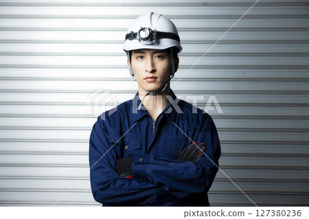 一名身穿工作服、雙臂交叉的男子 127380236