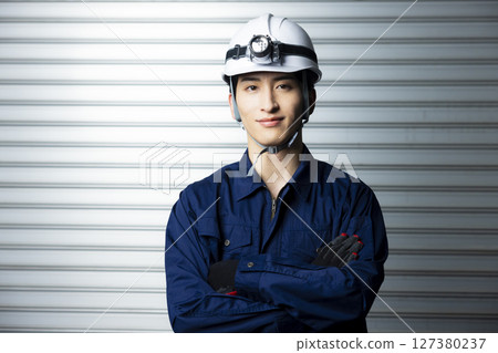 一名身穿工作服、雙臂交叉的男子 127380237