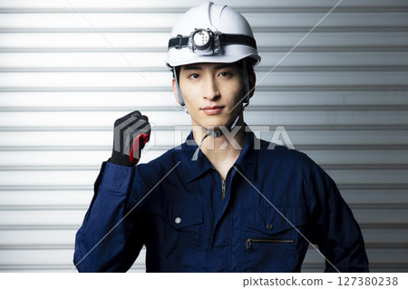 A man in work clothes with his arms folded 127380238