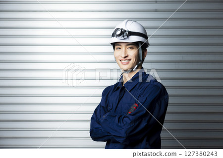 一名身穿工作服、雙臂交叉的男子 127380243