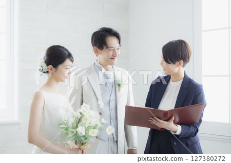 Bride and groom and host 127380272