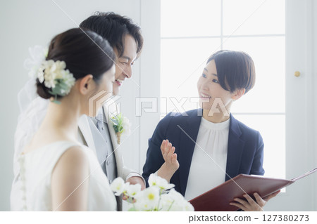 Bride and groom and host 127380273