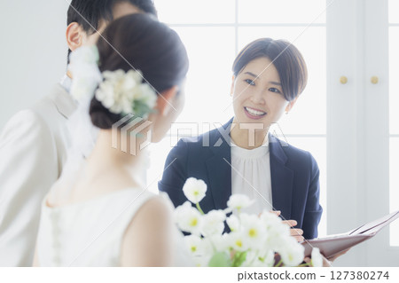 Bride and groom and host 127380274