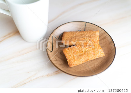 Financiers on a wooden plate and a white mug ④ Financiers on a wooden plate and a white mug ④ 127380425
