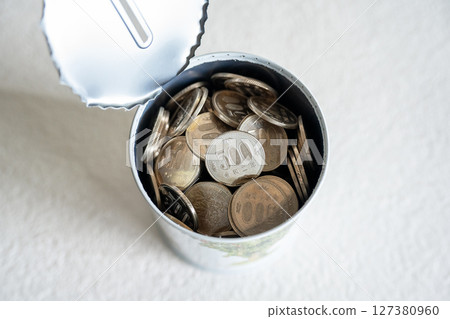 Opening a tin 500 yen coin piggy bank 127380960