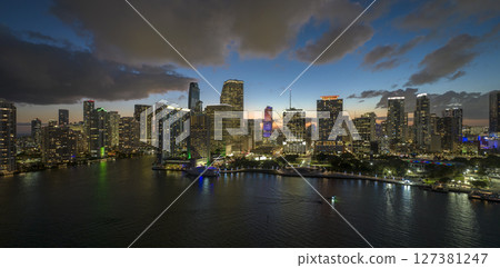 View from above of brightly illuminated high skyscraper buildings in downtown district of Miami Brickell in Florida, USA. American megapolis with business financial district at night 127381247
