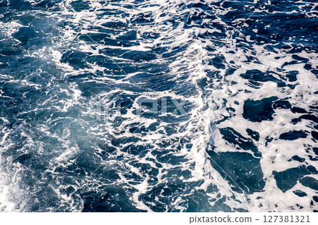 Top down aerial view of sea water surface. White foam waves texture as natural background. Top down aerial view of sea water surface. White foam waves texture as natural background. 127381321