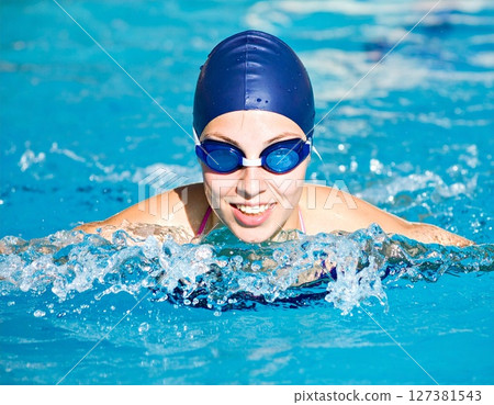 一位年輕女子在泳池裡微笑游泳。 AI 產生的影像 127381543