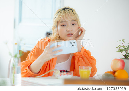 早餐：一位女士正在看她的智慧型手機 127382019