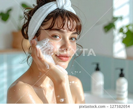 A young woman washing her face with creamy foam in her hands 1 AI-generated image 127382054