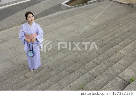 Young Japanese woman in kimono standing on the stairs Young Japanese woman in kimono standing on the stairs 127382156
